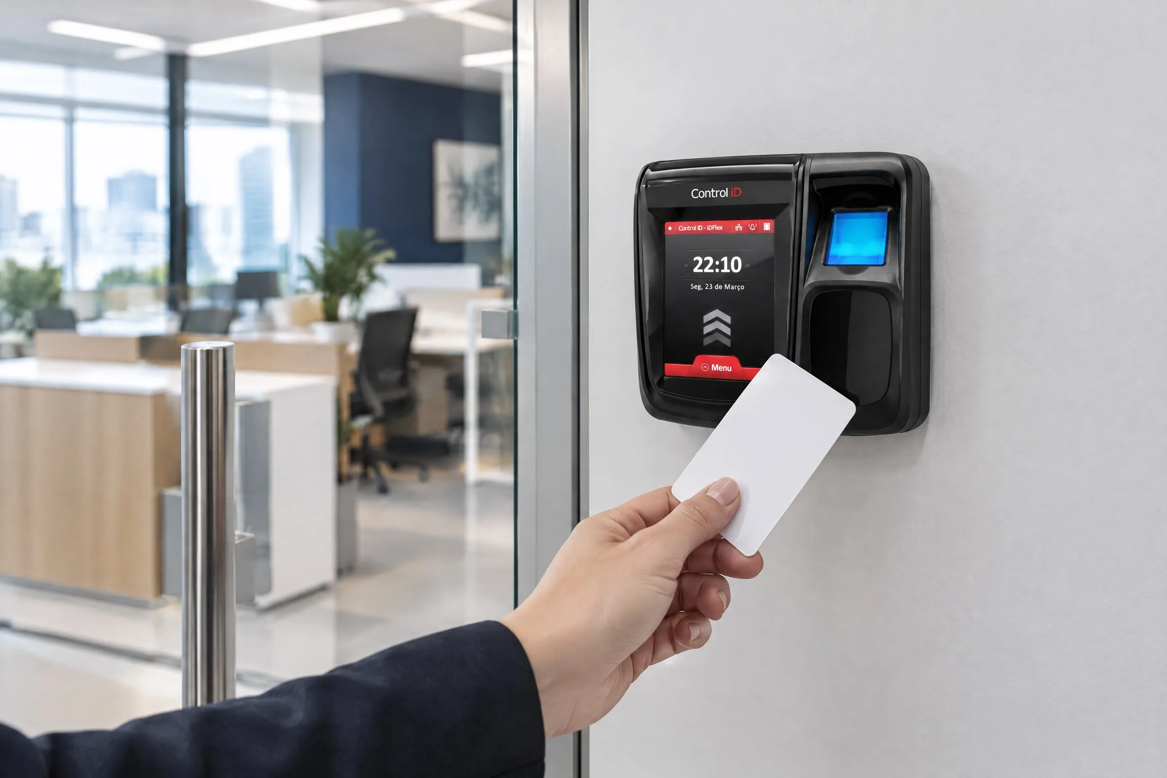 Terminal de controle de acesso Control iD iDFlex instalado ao lado de uma porta de vidro de escritório; uma mão aproxima um cartão